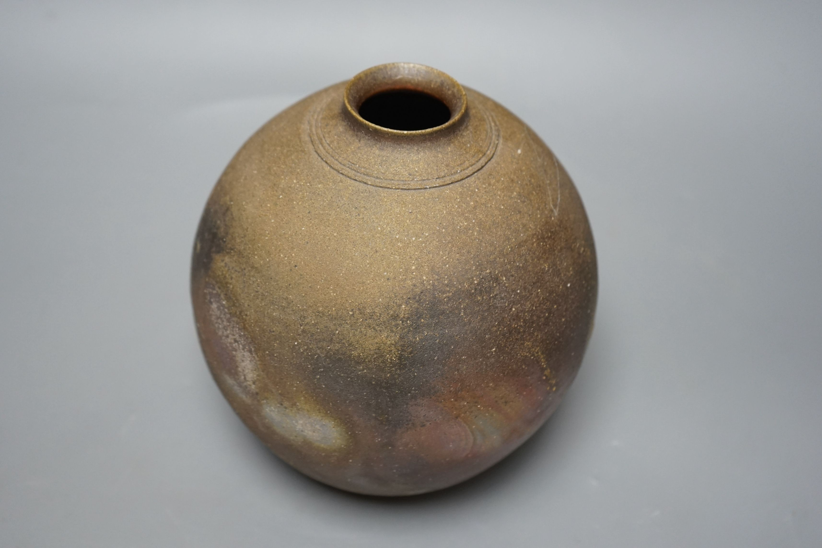 Japanese studio pottery: a boxed black glaze stoneware unomi tea bowl, with impressed mark, together with a ovoid vase, marked, 21cm tall